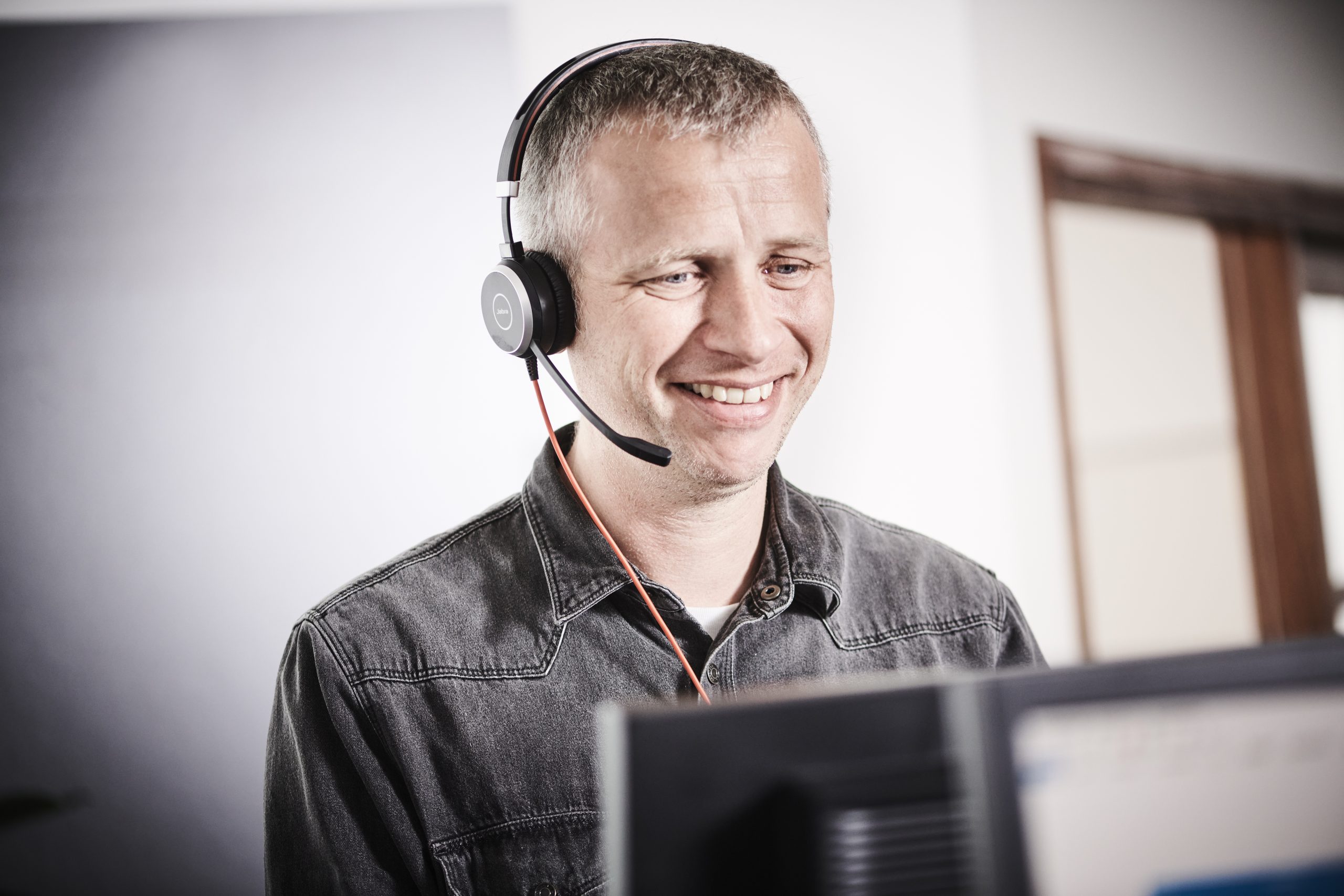 18066 – 59 Et billede af en InfoSuite-medarbejder foran en computerskærm og med headset på.